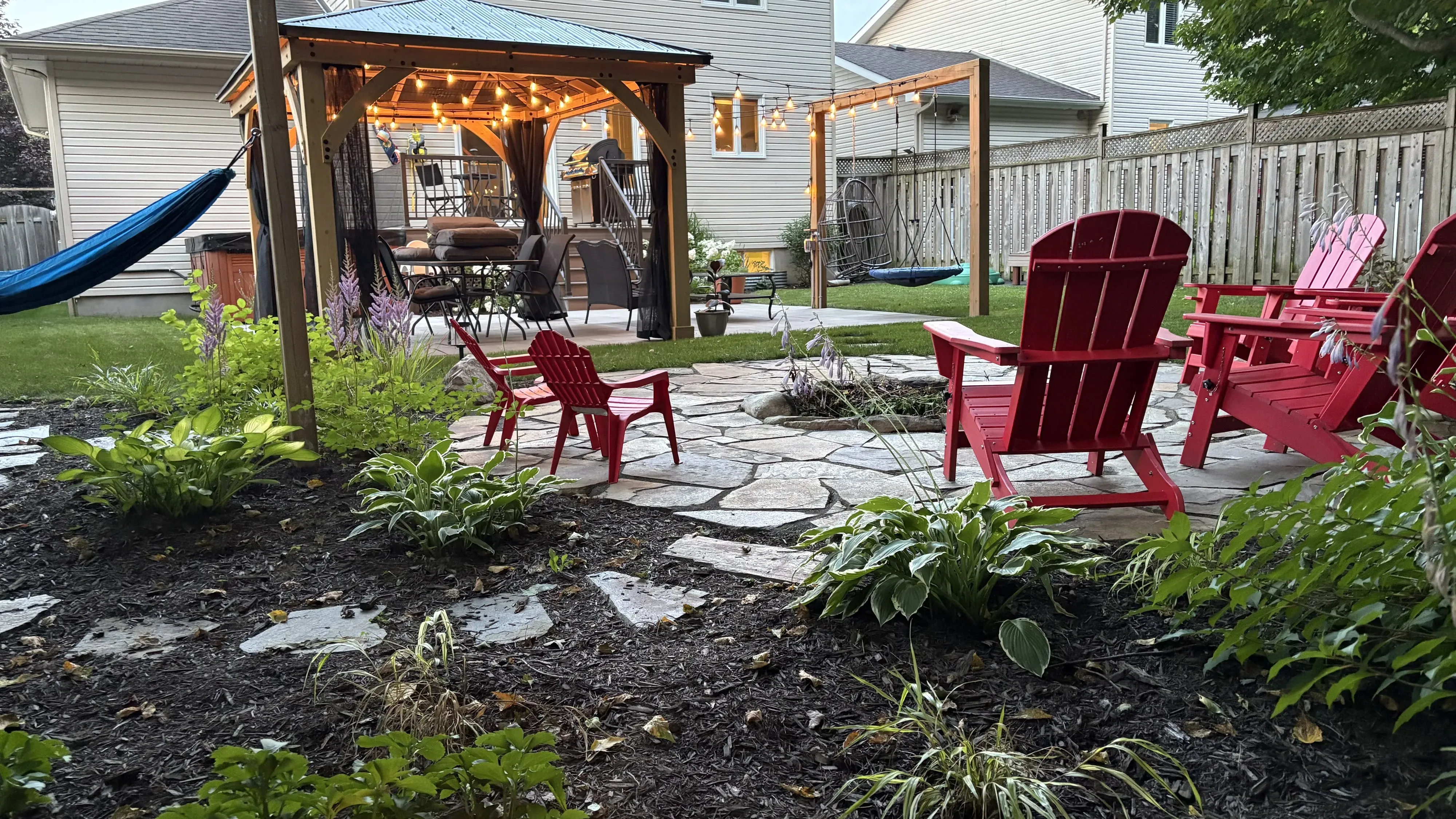 Flagstone garden patio with a covered dining area and layered planting